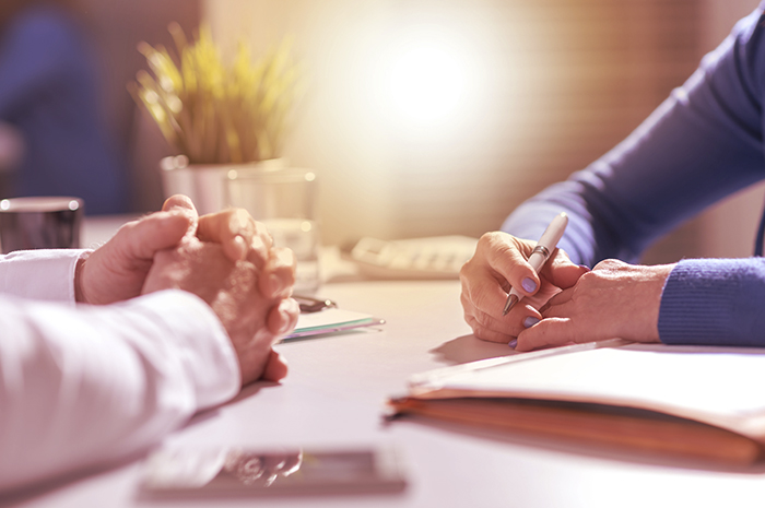 pessoas assinando contrato de compra e venda de imóvel