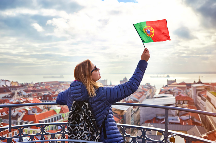 uma mulher segurando a bandeira de Portugal